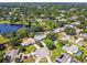 An aerial view showing houses with pools and backyards surrounded by mature trees by a pond at 7618 Majestic Pine Ct, Orlando, FL 32819