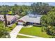 Aerial view of a brick home with a large front yard, two-car garage and a glimpse of the nearby lake at 7618 Majestic Pine Ct, Orlando, FL 32819