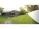 This backyard has a screen enclosed in-ground pool, a tall white fence, and manicured lawn at 7618 Majestic Pine Ct, Orlando, FL 32819