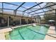 This screened-in pool with a spa is perfect for outdoor entertaining with the convenience of a built-in outdoor kitchen at 7618 Majestic Pine Ct, Orlando, FL 32819