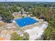 Aerial view of blue outdoor basketball and sand volleyball courts surrounded by green foliage at 7618 Majestic Pine Ct, Orlando, FL 32819