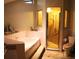 Retro bathroom with pink tile, a soaking tub, standing shower, toilet, and a miniature city skyline replica at 7618 Majestic Pine Ct, Orlando, FL 32819