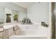 Bright bathroom featuring a large soaking tub with tiled surround, and a mirrored vanity at 7618 Majestic Pine Ct, Orlando, FL 32819