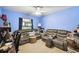 Bedroom featuring blue walls, ceiling fan, window, sofa, and a wooden table at 7618 Majestic Pine Ct, Orlando, FL 32819