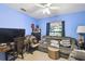 Blue bedroom with fan, a wooden desk, and a comfy grey couch by the window at 7618 Majestic Pine Ct, Orlando, FL 32819