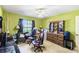 Green bedroom with a window, ceiling fan, makeup table, desk, and a dresser at 7618 Majestic Pine Ct, Orlando, FL 32819
