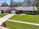 Well-manicured lawn of a beautiful brick home with an attached two-car garage and inviting curb appeal at 7618 Majestic Pine Ct, Orlando, FL 32819