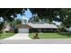 Charming single-story home featuring a well-maintained lawn, brick accents, and mature trees at 7618 Majestic Pine Ct, Orlando, FL 32819