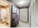 Hallway featuring a purple wall, white doors, and a wooden bench with a colorful blanket at 7618 Majestic Pine Ct, Orlando, FL 32819