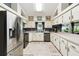 Functional kitchen features stainless steel appliances, white cabinets, and a window providing natural light at 7618 Majestic Pine Ct, Orlando, FL 32819