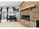 Cozy living room featuring a brick fireplace, plush carpeting, and sliding glass doors for ample natural light at 7618 Majestic Pine Ct, Orlando, FL 32819