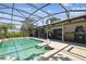 An inviting screened-in pool and covered patio are perfect for outdoor relaxation and entertaining near the wet bar at 7618 Majestic Pine Ct, Orlando, FL 32819