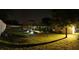 Spacious backyard with a screened-in pool, illuminated at night, and surrounded by lush greenery at 7618 Majestic Pine Ct, Orlando, FL 32819