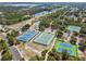 Aerial view of multiple well-maintained tennis courts, surrounded by lush greenery and parking area at 7618 Majestic Pine Ct, Orlando, FL 32819