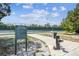 View of tennis courts in community with information sign and refreshing water fountain at 7618 Majestic Pine Ct, Orlando, FL 32819