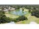 Aerial view featuring a picturesque pond, golf course, and community homes amidst lush greenery and mature trees at 8443 Sw 109Th Pl, Ocala, FL 34481