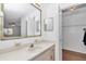Bright bathroom with large mirror, vanity with drawers, and open door to the walk-in closet at 8443 Sw 109Th Pl, Ocala, FL 34481