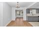 Dining room with hardwood floors, modern chandelier, and view to kitchen and sunroom at 8443 Sw 109Th Pl, Ocala, FL 34481