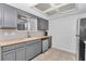 Kitchen featuring gray cabinets, stainless steel appliances, granite countertops, and tiled floors at 8443 Sw 109Th Pl, Ocala, FL 34481