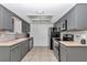 Galley kitchen with gray cabinets, stainless steel appliances, and tiled floors at 8443 Sw 109Th Pl, Ocala, FL 34481