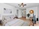 Bright main bedroom featuring a ceiling fan, a rug, and a view to the ensuite bathroom at 8443 Sw 109Th Pl, Ocala, FL 34481