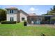 Stunning home featuring a screened-in pool area and beautifully maintained backyard with lush green grass and manicured hedges at 8475 Eagles Loop Cir, Windermere, FL 34786