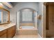 Elegant bathroom featuring a soaking tub, columns, and a walk-in shower at 8475 Eagles Loop Cir, Windermere, FL 34786