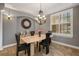 Elegant dining room features chandelier lighting, decorative wall clock, and window with plantation shutters at 8475 Eagles Loop Cir, Windermere, FL 34786