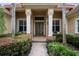 Inviting front entryway with decorative columns, manicured shrubs and brick walkway at 8475 Eagles Loop Cir, Windermere, FL 34786