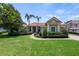 Charming home with a red tile roof, manicured lawn, and lush landscaping at 8475 Eagles Loop Cir, Windermere, FL 34786