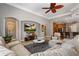 Open-concept living room showcasing a large TV and view into the kitchen at 8475 Eagles Loop Cir, Windermere, FL 34786