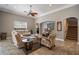 Comfortable living area with ceiling fan, tile flooring, and access to the second floor stairs at 8475 Eagles Loop Cir, Windermere, FL 34786