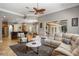 Open-concept living room with a ceiling fan, plush seating, and easy flow to the kitchen and outdoor patio at 8475 Eagles Loop Cir, Windermere, FL 34786