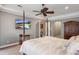 Comfortable primary bedroom with a TV, dark wood furniture, and a ceiling fan at 8475 Eagles Loop Cir, Windermere, FL 34786