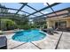 Screened-in pool with outdoor kitchen, patio furniture, and lush landscaping at 8475 Eagles Loop Cir, Windermere, FL 34786