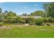 Charming single-story home with lush landscaping, mature trees, and stone accents at 98 Wisteria Dr, Longwood, FL 32779
