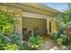 Cozy covered porch with stone accents, seating, and lush tropical landscaping at 98 Wisteria Dr, Longwood, FL 32779