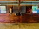 Indoor wooden horse stall, with two horses looking out and tools in reach on the wooden beams at 98 Wisteria Dr, Longwood, FL 32779