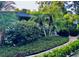 Beautiful landscaping featuring lush greenery and palm trees enhances the curb appeal of this home at 98 Wisteria Dr, Longwood, FL 32779