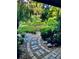 Beautifully landscaped garden pathway with stones and pebbles leading through lush greenery and tropical plants at 98 Wisteria Dr, Longwood, FL 32779