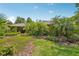 A view of the side of the home, with a lush, manicured lawn with mature trees and landscaping at 98 Wisteria Dr, Longwood, FL 32779