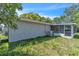 Backyard view featuring a screened patio attached to the stucco home at 107 Thrush Ln, Casselberry, FL 32707