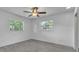 Bright bedroom boasts two windows, gray wood-look flooring, and a ceiling fan at 107 Thrush Ln, Casselberry, FL 32707