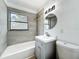 Modern bathroom with gray tile, vanity, mirror, and shower-over-tub combination at 1082 Hamilton Ave, Longwood, FL 32750