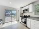 Bright kitchen with stainless steel oven and microwave, granite counters, and white cabinets at 1082 Hamilton Ave, Longwood, FL 32750
