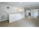 Open living room with white walls, recessed lighting, and wood-look floors leads to an open doorway at 1082 Hamilton Ave, Longwood, FL 32750
