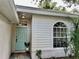 Inviting home entrance with a blue door, decorative window and pleasant landscaping at 11725 Cuxham Dr, Orlando, FL 32837
