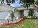 Inviting front exterior with manicured landscaping and a walkway leading to an arched front door at 11725 Cuxham Dr, Orlando, FL 32837