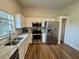 Kitchen boasts stainless steel appliances, wood-look floors, and bright white cabinetry at 11725 Cuxham Dr, Orlando, FL 32837