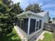 Corner view of screened porch with access door and paved walkway through green lawn at 11725 Cuxham Dr, Orlando, FL 32837